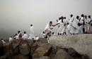 A Muslim pilgrim helps a fellow pilgrim on Mount Mercy on the plains of Arafat during the annual haj pilgrimage, outside the holy city of Mecca