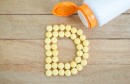 Yellow pills forming shape to D alphabet on wood background