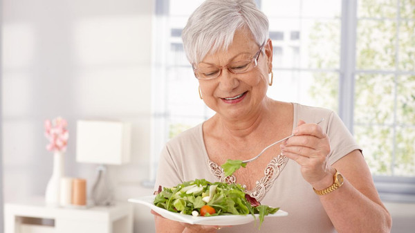 Old lady eating green salad